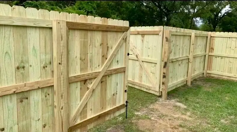 New pine privacy fence with a braced double gate, built by Southern Line Fence & Finish