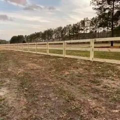 Three-rail wood fence across an open pasture