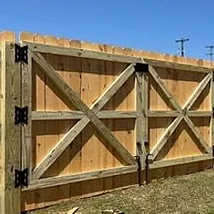 Pine privacy fence with an X-braced double gate on black hinges